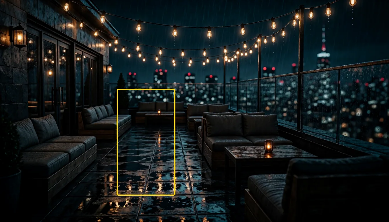 A rooftop lounge at night in the rain, with a yellow box drawn on the wet floor between the sofas