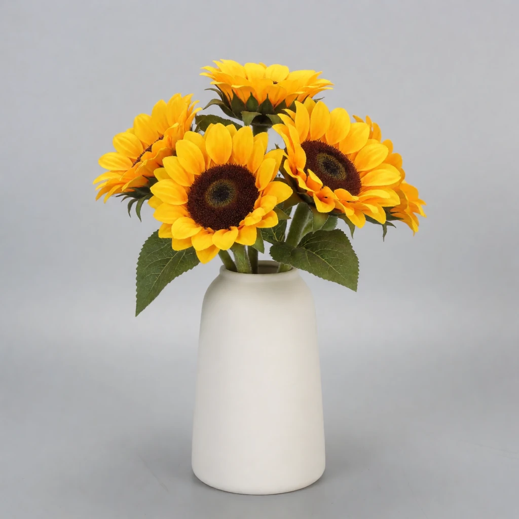 Reference 9: a white ceramic vase of sunflowers on a plain grey background