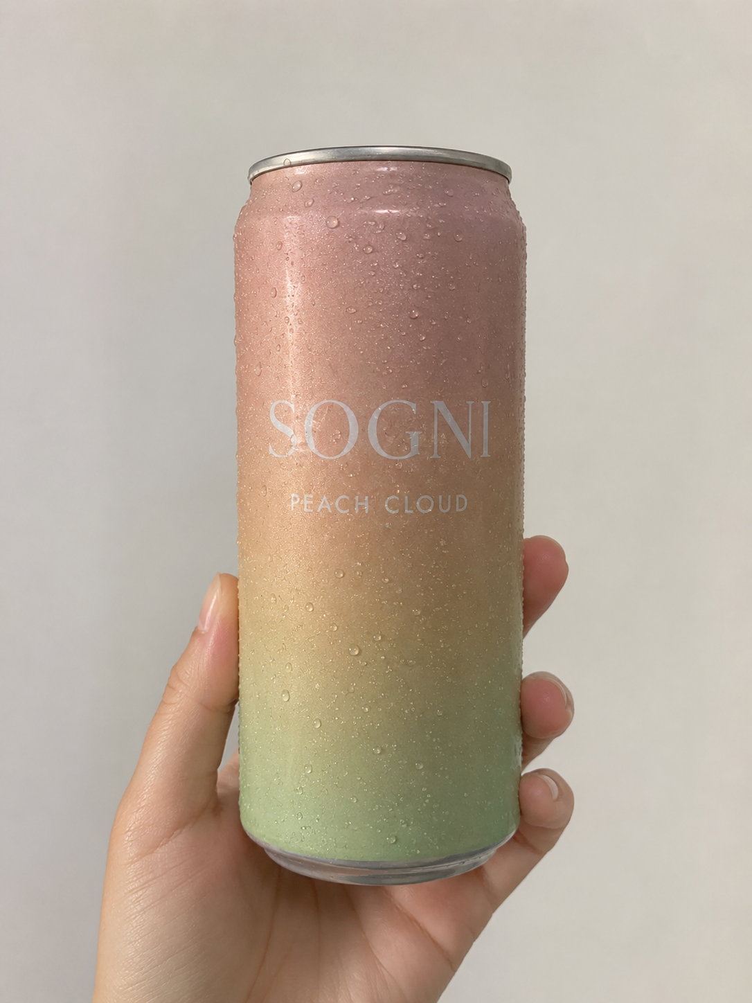 Reference photo: a pastel gradient Sogni Peach Cloud can held in a hand